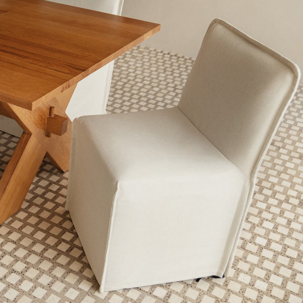 Washable slipcover dining chair in white highlighting sustainable materials and carbon-neutral shipping.