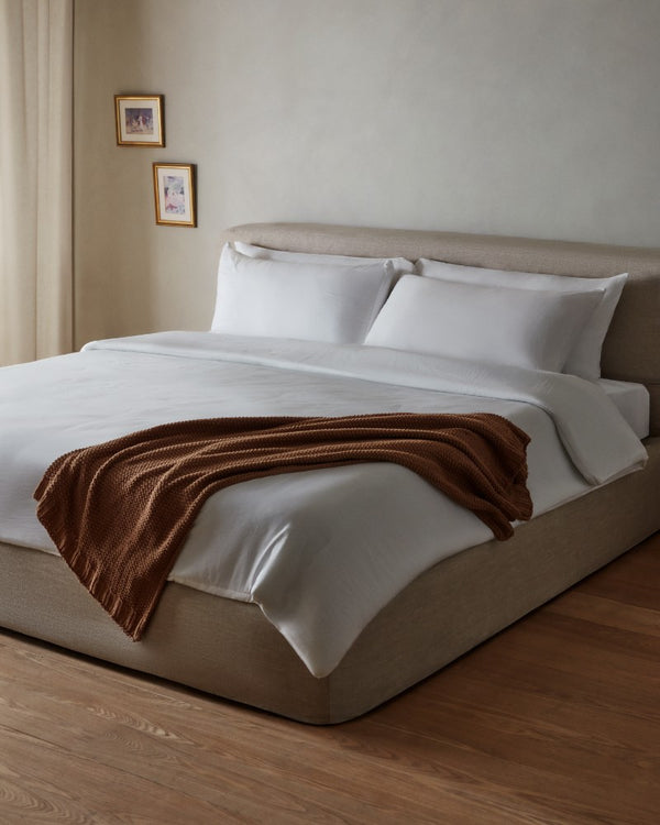 Lifestyle image of a platform bed with upholstered headboard in Oat fabric highlighting the upholstered platform bed collection.