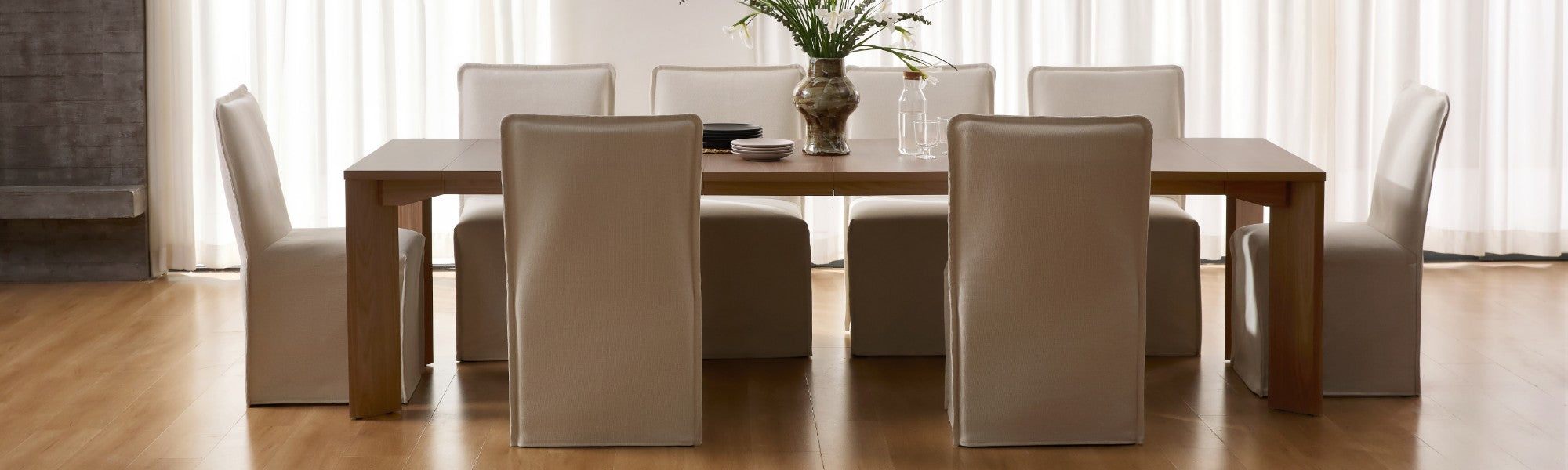 Lifestyle banner image of washable dining chairs in eggshell fabric styled in a real home setting around a walnut extendable dining table, highlighting a 30-day risk-free trial.