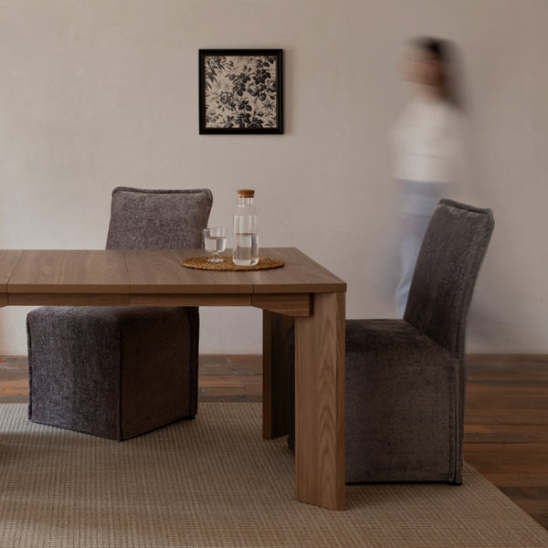Lifestyle of walnut wood extendable dining table with washable slipcover dining chairs in Caviar