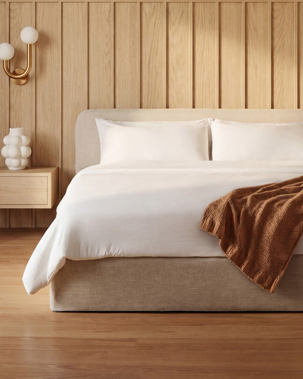 Lifestyle image of a platform bed with upholstered headboard in Oat fabric highlighting the upholstered platform bed collection.
