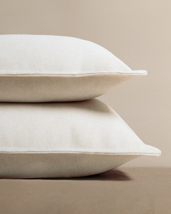 Lifestyle image of stacked throw pillows in Eggshell fabric highlighting the washable throw pillow collection.
