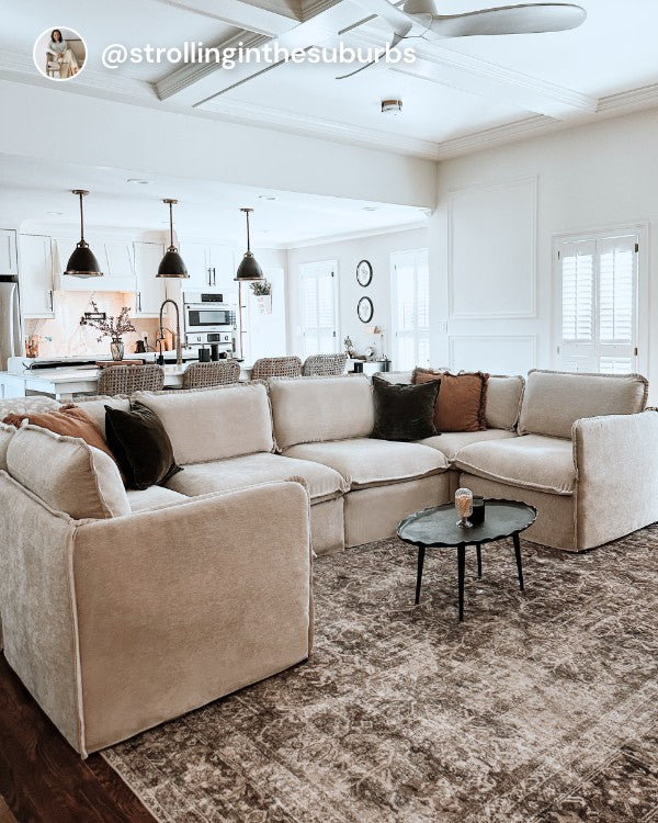 Lifestyle image of a Modular Performance 6-Seater U-Sectional + Ottoman in Mist fabric, shown in a real customer home setting.