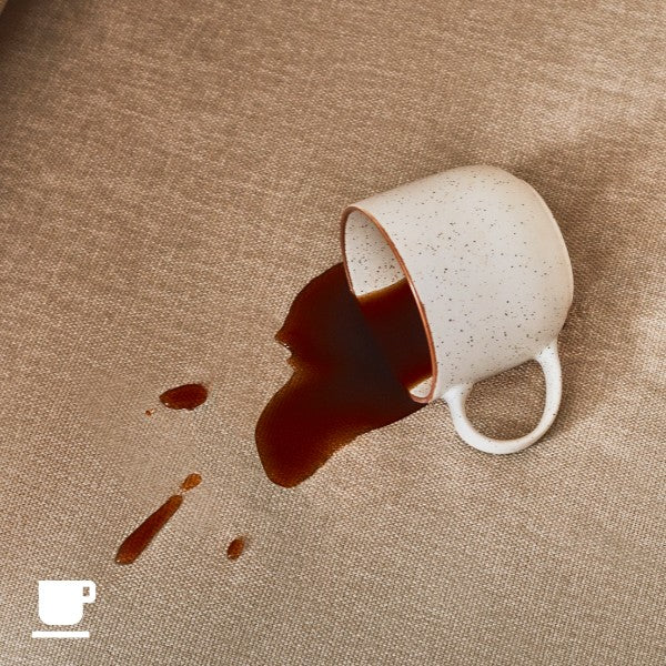 Close-up spill shot of coffee on modular sofa fabric highlighting stain-resistant and liquid-resistant performance for everyday living.